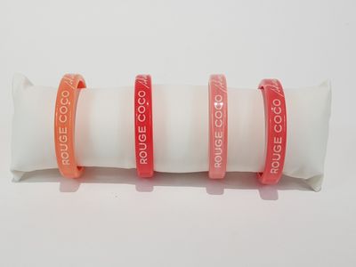 three red and white bracelets are stacked on top of each other