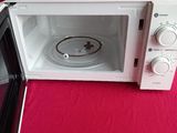 a white microwave oven sitting on a red table