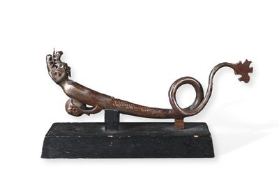 une sculpture métallique représentant un lézard posé sur un socle en bois