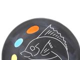 a black plate with a drawing of a fish on it