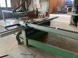 a machine that is cutting a piece of wood in a room