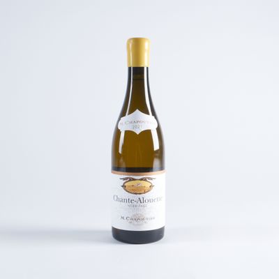 une bouteille de vin blanc posée sur une table blanche