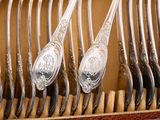many spoons and forks in a box on the table