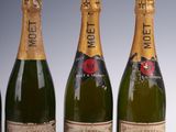 four bottles of champagne are lined up in a row
