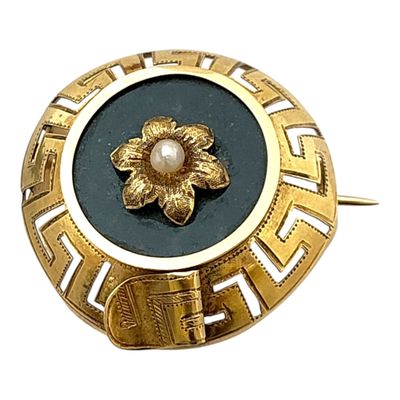 une broche en or ornée d'une perle au centre