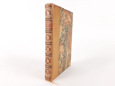 an old book sitting on top of a white table next to a white wall
