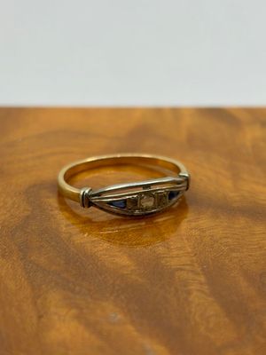 a close up of a gold ring on a wooden table