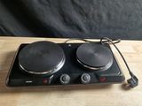 an electric stove top with two burners on a wooden table