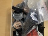 un récipient en plastique rempli de produits de maquillage posé sur une table en bois