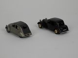 two toy cars sitting next to each other on a white surface