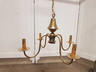 un lustre ancien en laiton suspendu au plafond d'une pièce