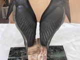 two birds that are sitting on top of a marble block