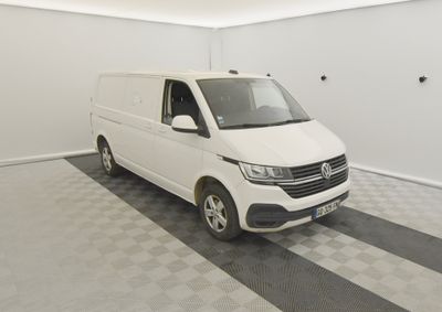 La camionnette blanche est garée dans une pièce propre dont le sol est recouvert d'un revêtement à carreaux.