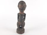 une vieille statue en bois représentant un homme au visage noir