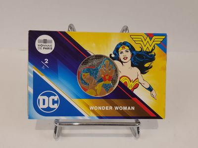 a close up of a coin on a stand with a picture of wonder woman