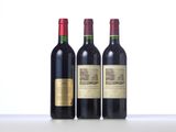 three bottles of red wine are lined up on a table