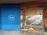 un tableau accroché au mur au-dessus d'un lavabo dans une salle de bains