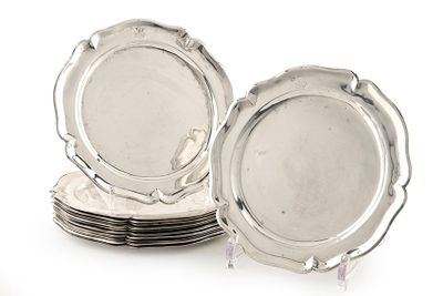 plusieurs assiettes en argent empilées les unes sur les autres sur une surface blanche