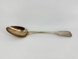 an antique silver spoon with a spoon handle on a white surface