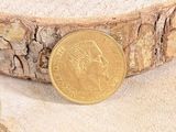 une pièce d'or posée sur un morceau de bois
