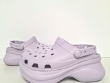 purple crocs shoes with holes on them on a white surface