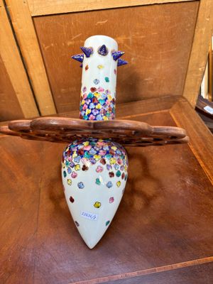 un vase surmonté d'un oiseau, posé sur une table