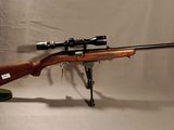 Le fusil est posé sur un support et est équipé d'une lunette
