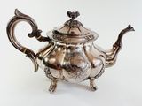an antique silver teapot with a handle and handle on a white background