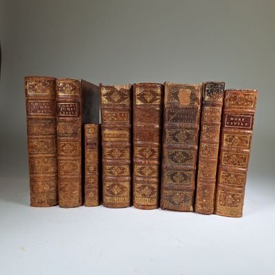 several old books are lined up in a row on a table