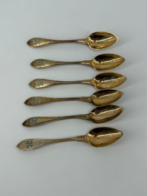 six spoons are lined up in a row on a white surface