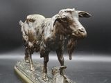 bronze statue of a goat and a cat on a platform