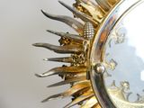 a gold sunburst that is hanging on the wall