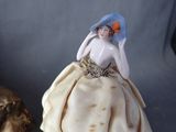a figurine of a woman in a dress and hat