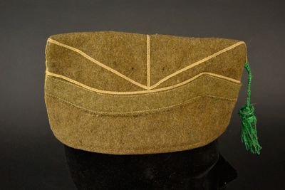 un sac en papier brun orné d'un pompon vert