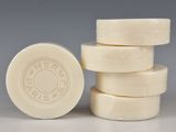 quatre pains de savon blancs empilés les uns sur les autres sur une table