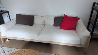 un canapé blanc orné de coussins rouges dans un salon