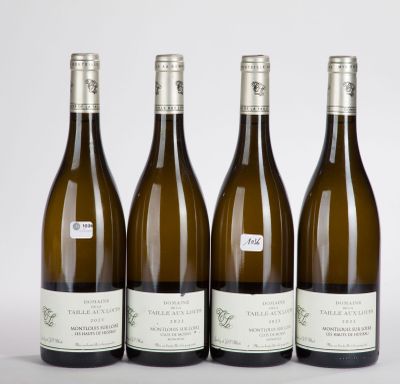 three bottles of wine are lined up on a white surface