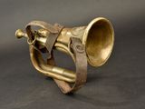 an old brass trumpet with a leather band on a black background