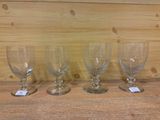 trois verres à vin vides sont alignés sur une étagère en bois