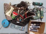 a bag full of tools sitting on the floor next to a pair of scissors