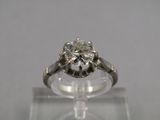 un gros plan d'une bague en diamant posée sur un socle transparent