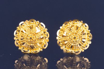 une paire de boucles d'oreilles en or sur une surface noire