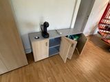 a coffee maker on a cabinet in the corner of a room