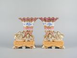 paire de vases roses et blancs rehaussés de touches dorées, posés sur des socles