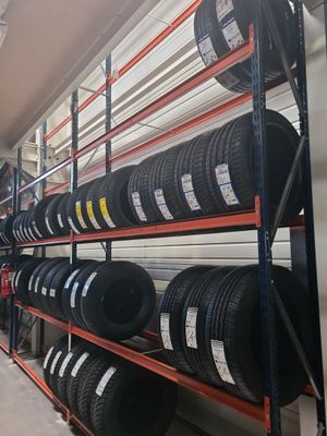 tires on a rack in a warehouse with shelves full of tires
