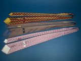 four ties are lined up in a row on a blue surface