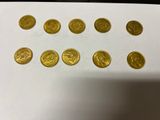 a bunch of gold coins sitting on top of a white table