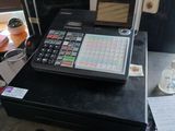 un ordinateur portable posé sur une caisse enregistreuse