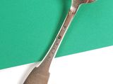 a spoon that is sitting on top of a piece of paper