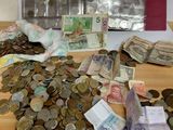 a pile of money sitting on a table next to some coins